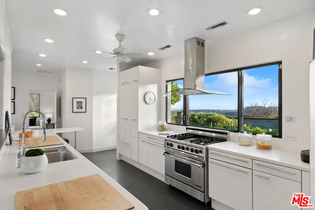 1820 Braemar Road Pasadena, CA 91103 - Photo 34 of 75 a kitchen with a stove a sink a refrigerator and a dining table with wooden floor