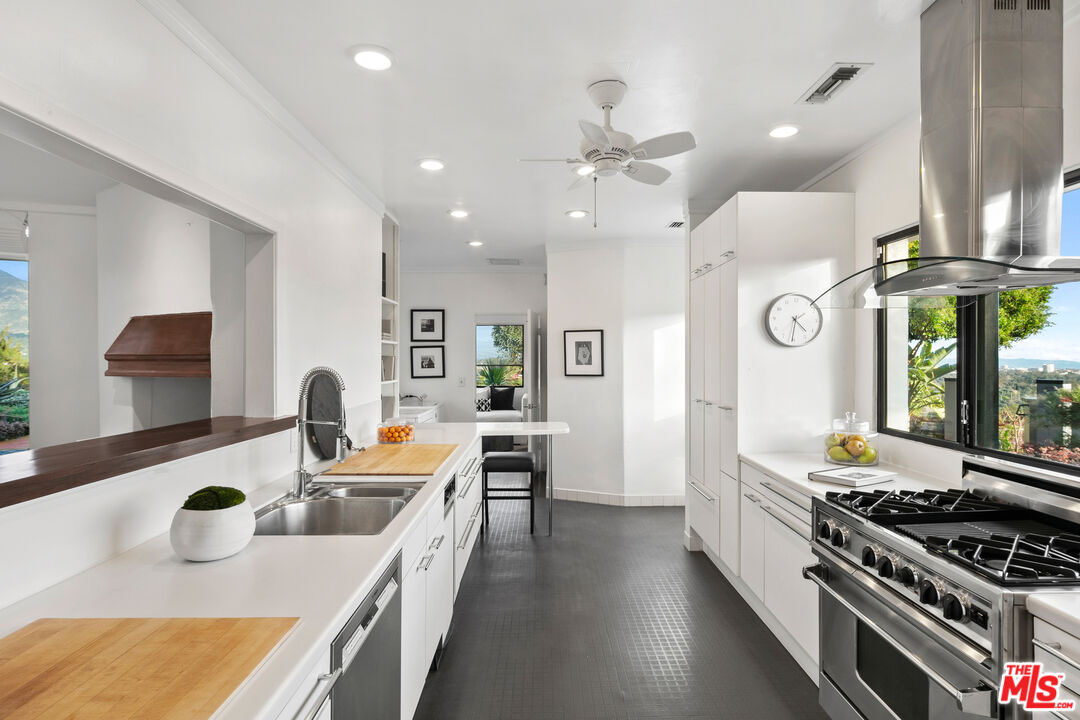 1820 Braemar Road Pasadena, CA 91103 - Photo 35 of 75 a kitchen with a stove a refrigerator and a dining table with wooden floor