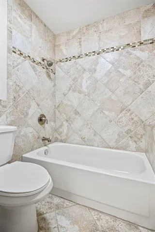 a bathroom with a toilet and a bath tub