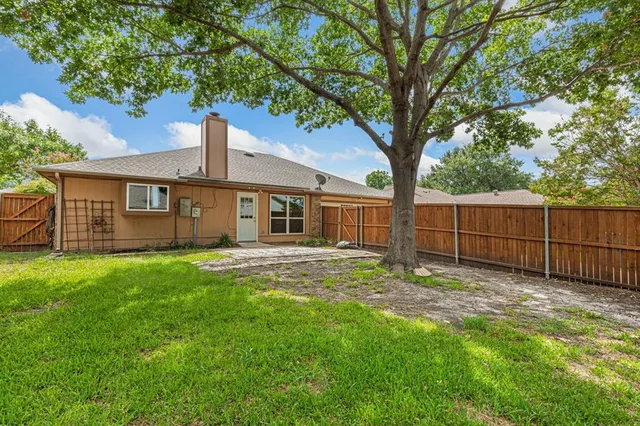 a view of a house with backyard and a tree