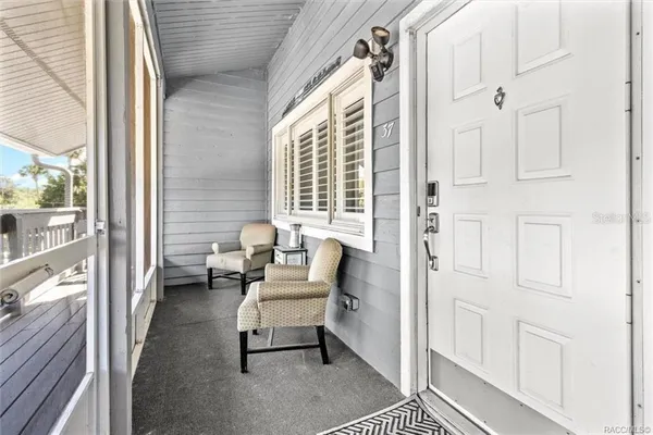 a view of a chair and table in the back yard of the house