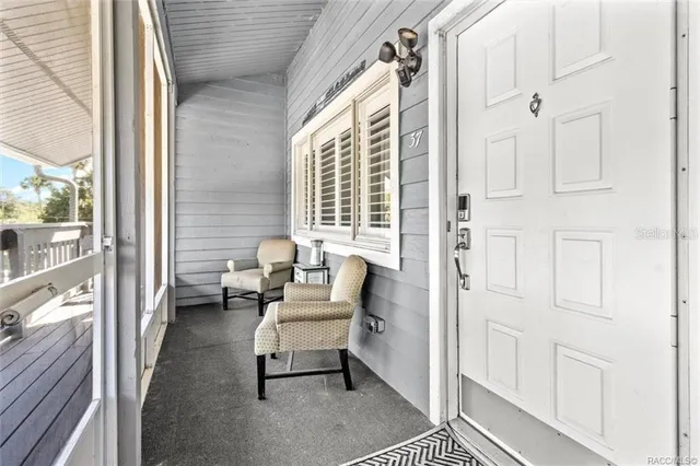 a view of a chair and table in the back yard of the house
