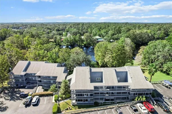an aerial view of a house with a yard and lake view