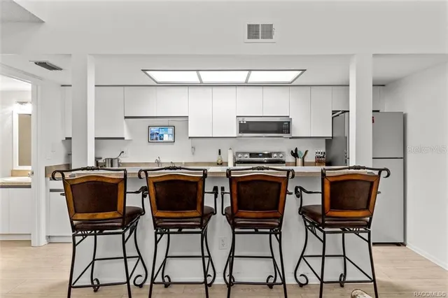 a kitchen with stainless steel appliances granite countertop a sink a stove top oven a counter space and cabinets