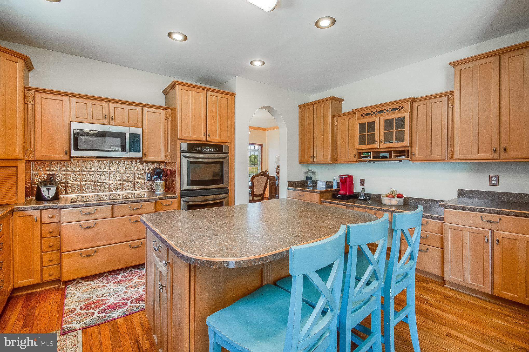 11425 Custers Trace Spotsylvania, VA 22553 - Photo 13 of 60 a kitchen with granite countertop a stove top oven a sink a dining table and chairs