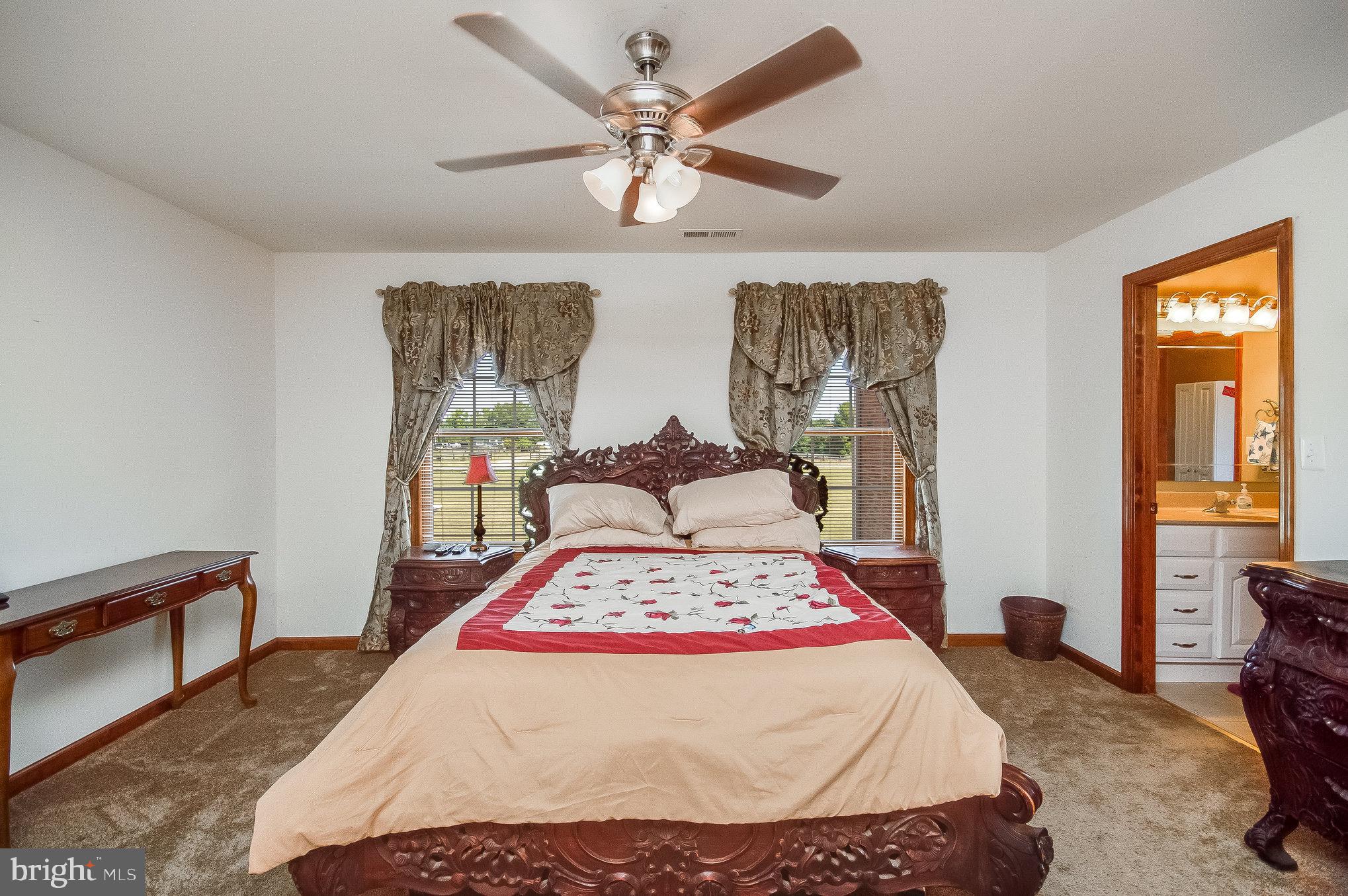 11425 Custers Trace Spotsylvania, VA 22553 - Photo 34 of 60 a bed sitting in a bedroom next to a window with a chandelier and a wooden floor