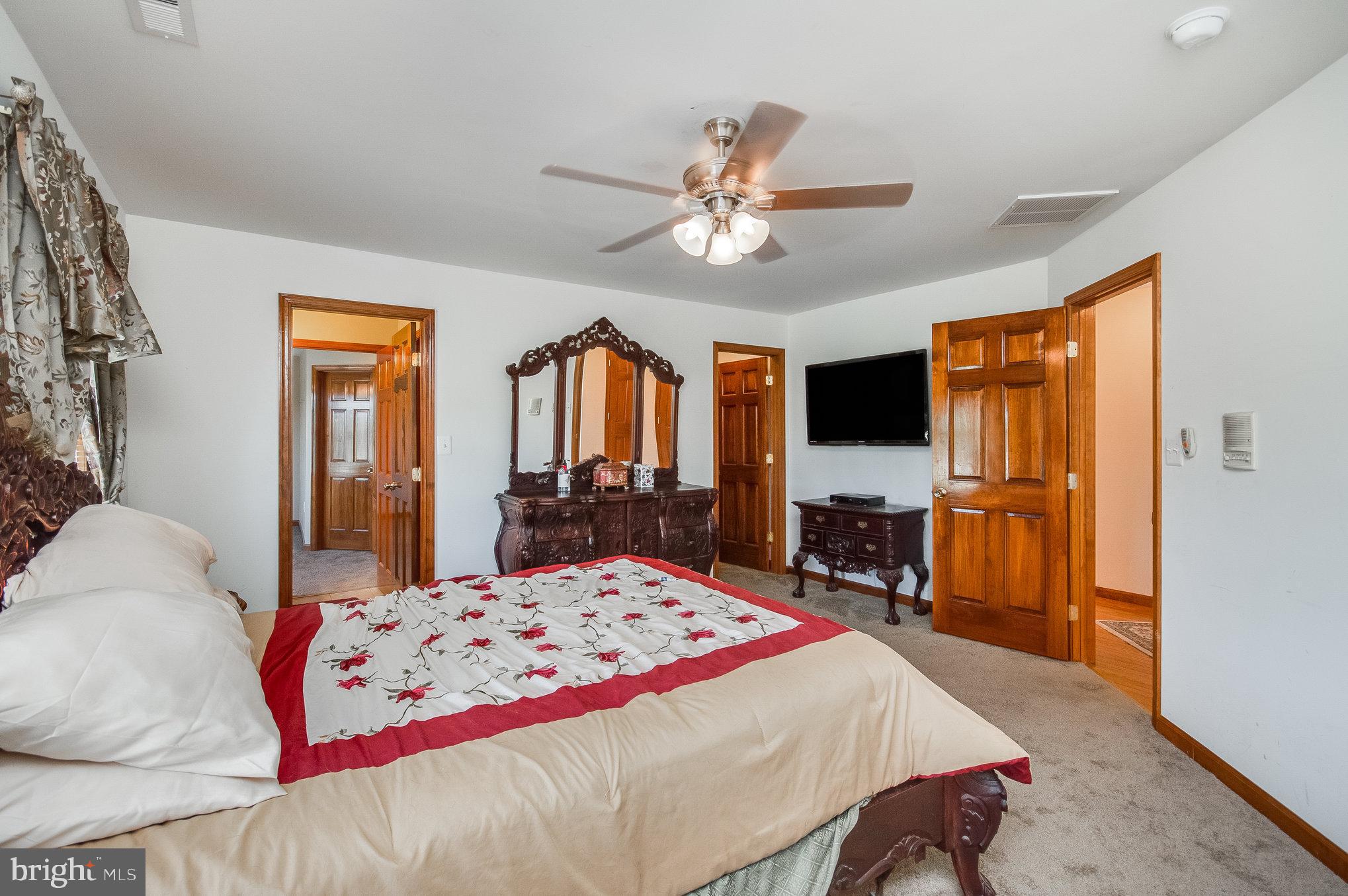 11425 Custers Trace Spotsylvania, VA 22553 - Photo 35 of 60 a bedroom with a bed and dresser with mirror