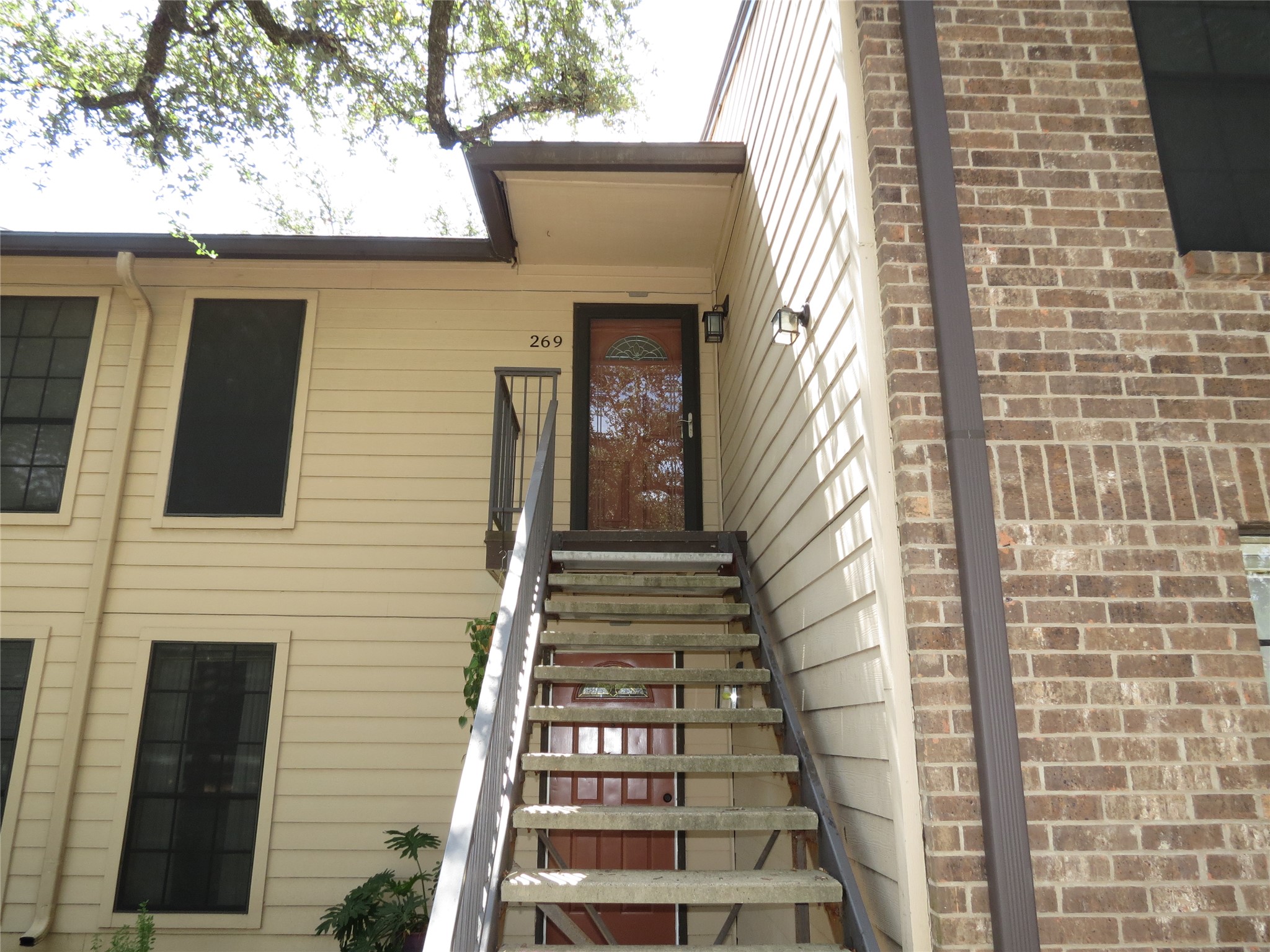 4159 Steck Avenue, Unit 269 Austin, TX 78759 - Photo 2 of 21 A welcoming front entrance showcases classic brick and siding, leading to an upper-level unit.
