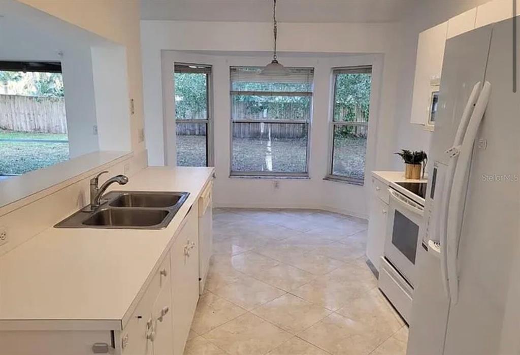 709 Southwest Aster Road Port St. Lucie, FL 34953 - Photo 4 of 6 a kitchen with stainless steel appliances a sink a stove a refrigerator a window
