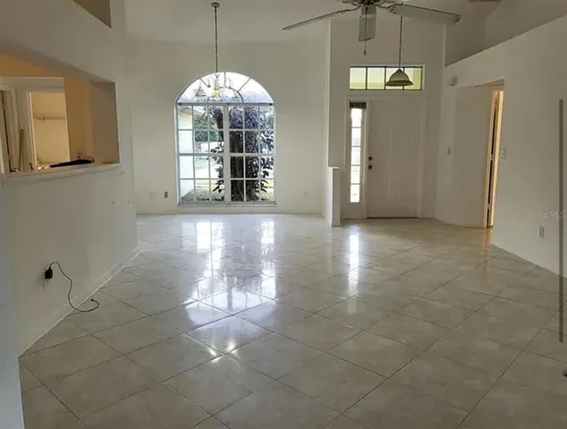 a view of a big room with windows and chandelier