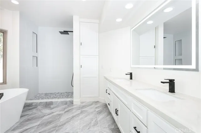 a bathroom with a tub sink and mirror