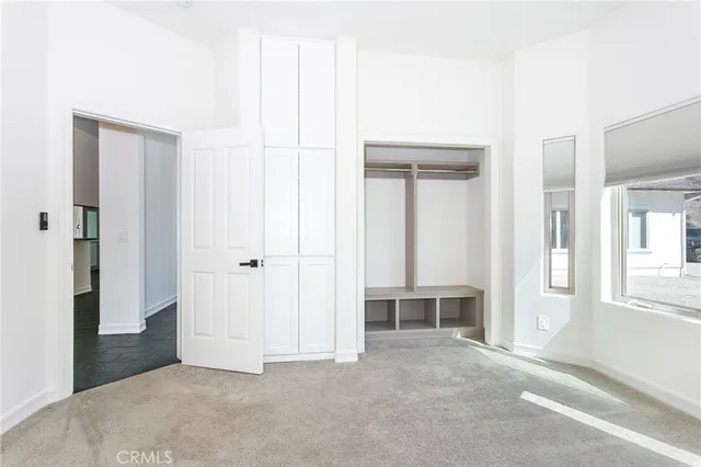 an empty room with windows and closet