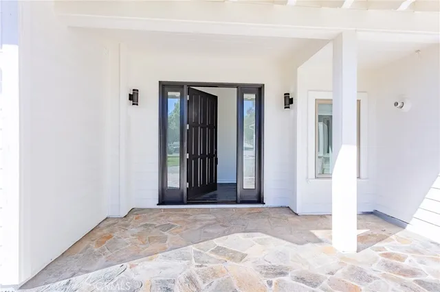 a view of a hallway with wooden floor and a bathroom