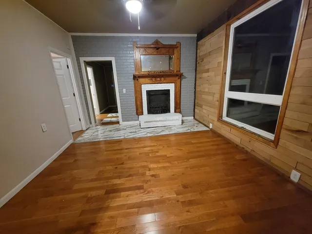 a view of an empty room with a fireplace and a window