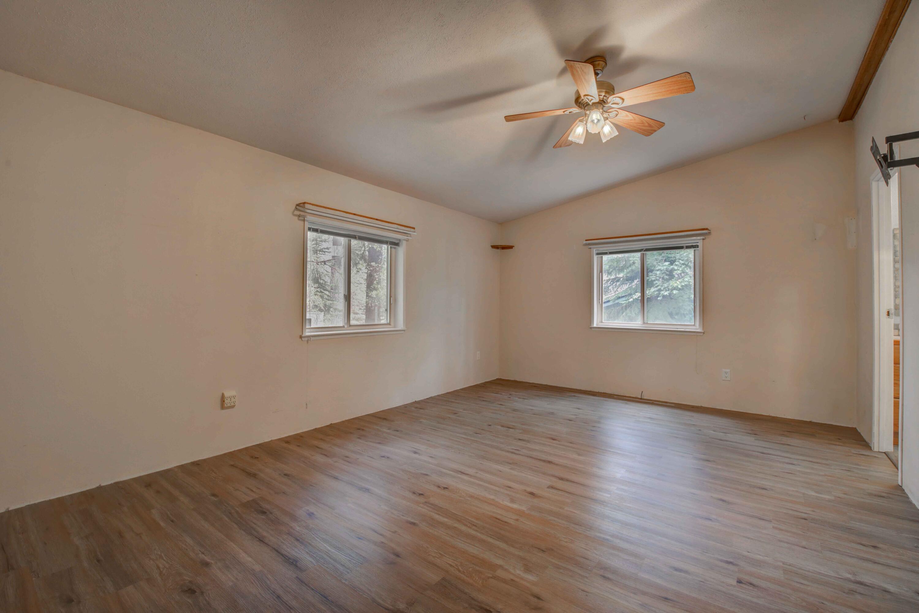 60184 Crater Road Bend, OR 97702 - Photo 11 of 29 Primary bedroom suite with vinyl plank wood style flooring, vaulted ceiling, ceiling fan, and large walk in closet.