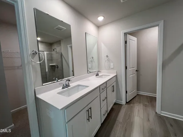 a bathroom with a double vanity sink mirror and shower