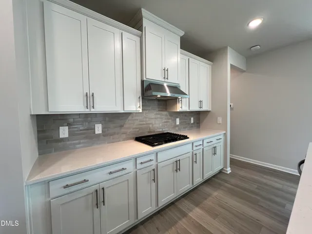 a large kitchen with stainless steel appliances kitchen island a large counter top and a refrigerator