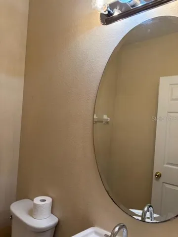 a bathroom with a sink a toilet and a mirror