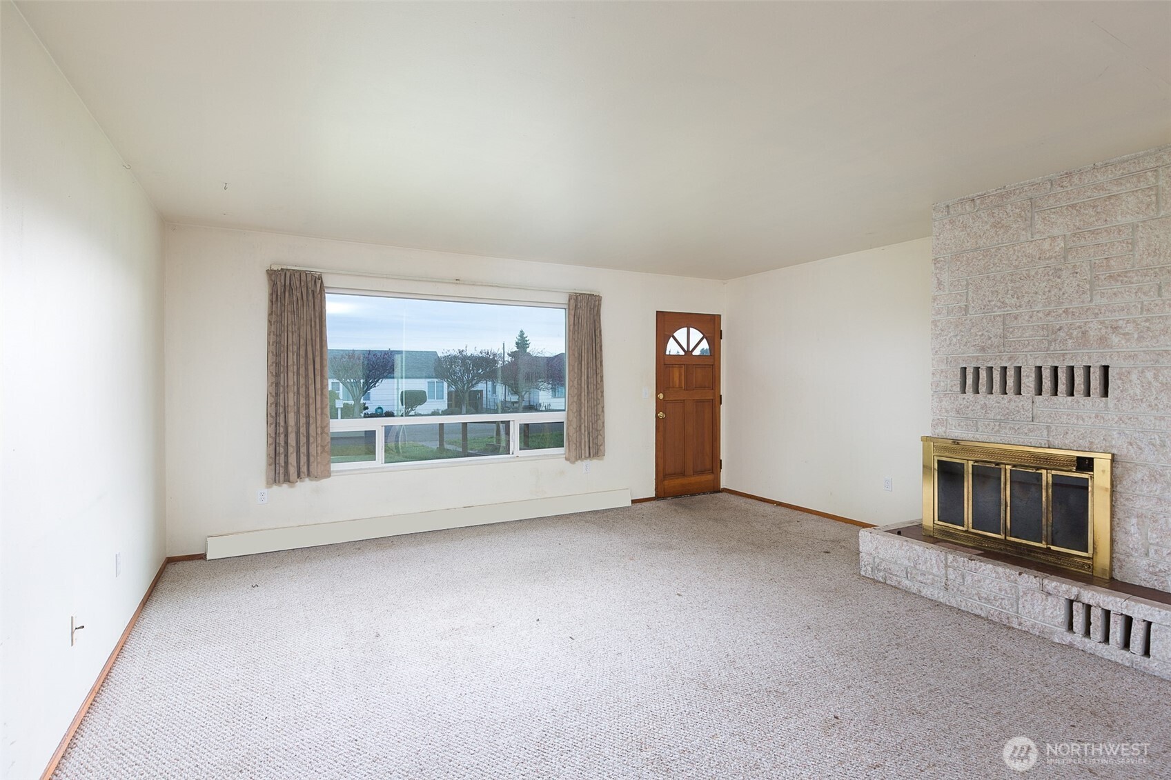 910 East 7th Street Port Angeles, WA 98362 - Photo 3 of 33 an empty room with a fireplace and window