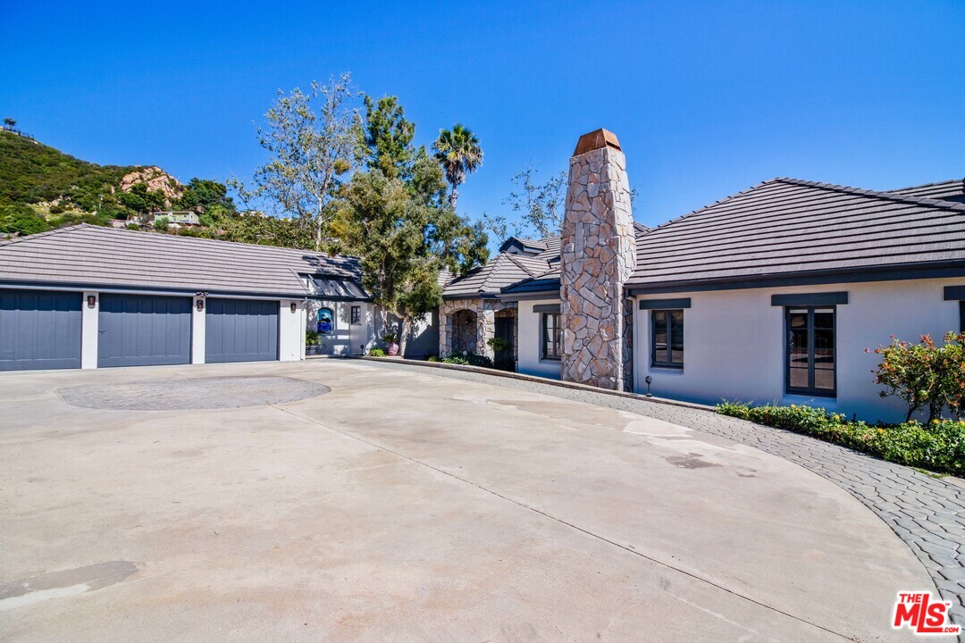 210 Lorine Lane Malibu, CA 90265 - Photo 15 of 48 a front view of a house with a yard and garage