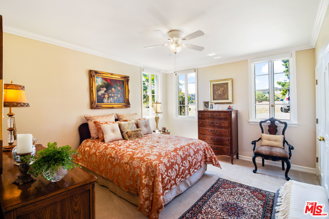 210 Lorine Lane Malibu, CA 90265 - Photo 30 of 48 a bedroom with a bed and a chandelier