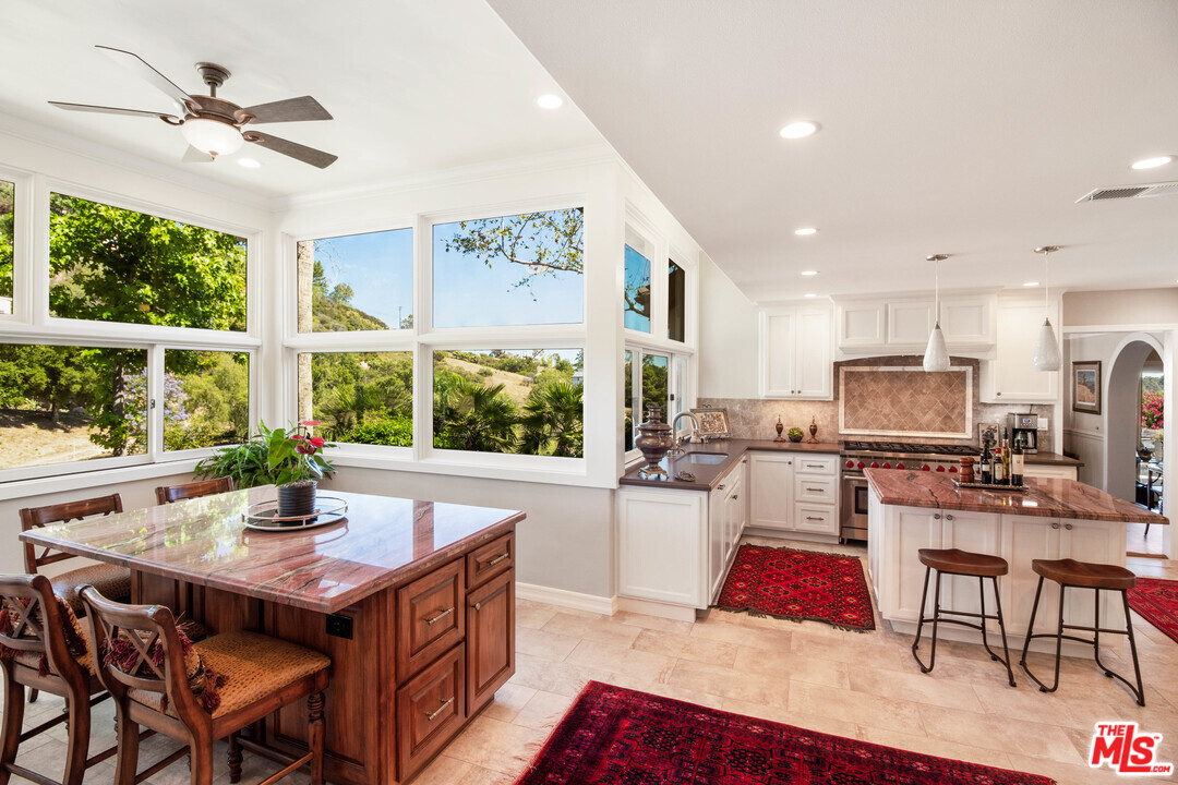 210 Lorine Lane Malibu, CA 90265 - Photo 4 of 48 a kitchen with stainless steel appliances granite countertop a stove a refrigerator a kitchen island a couches and dinning table with wooden floor