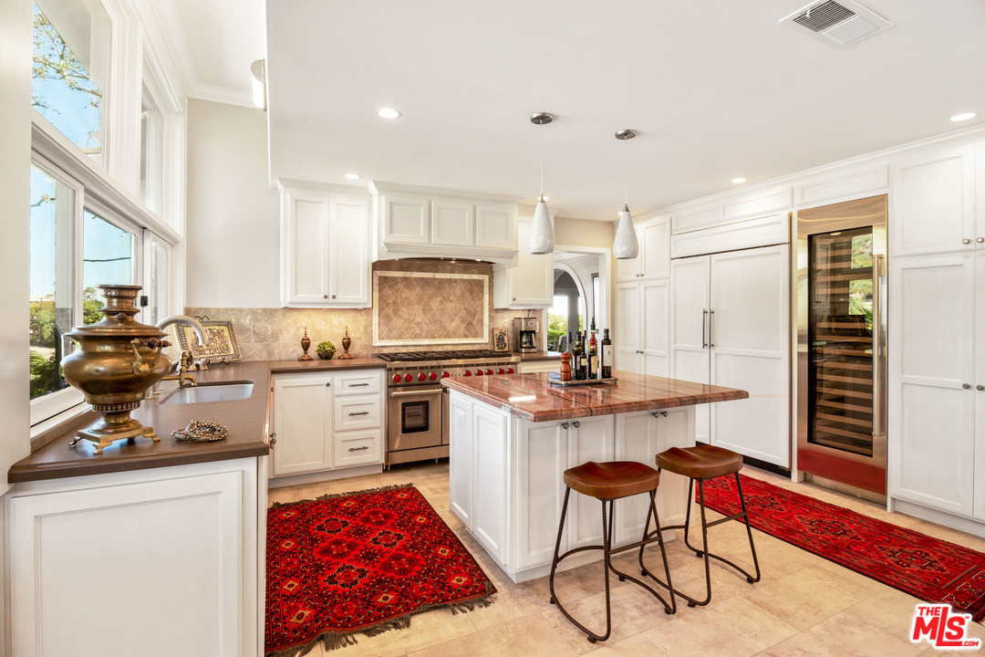 210 Lorine Lane Malibu, CA 90265 - Photo 32 of 48 a kitchen with a sink a stove cabinets and counter space