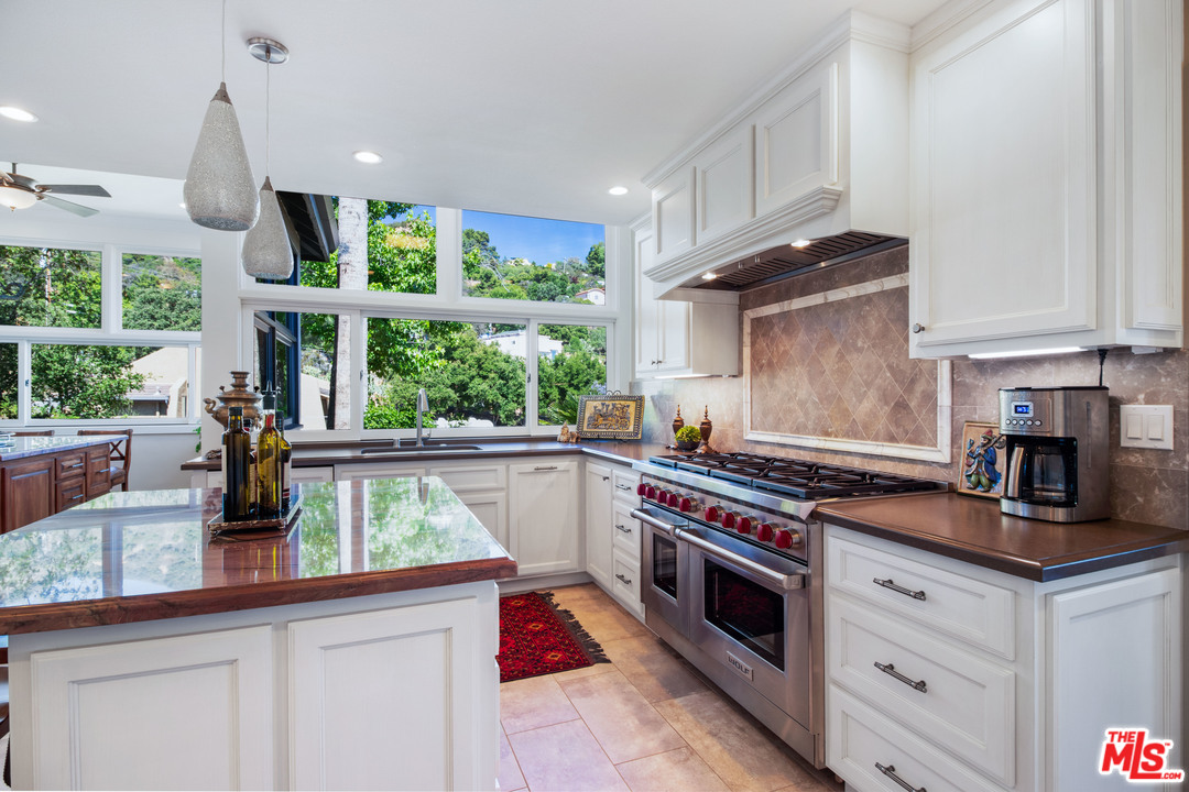 210 Lorine Lane Malibu, CA 90265 - Photo 8 of 48 a view of a kitchen with a sink wooden cabinets and a window