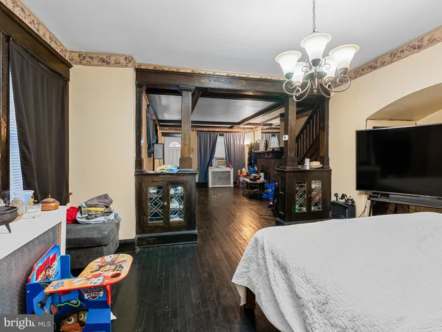 a living room with furniture a flat screen tv and a chandelier