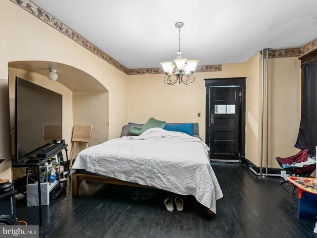 a spacious bedroom with a bed and a flat screen tv