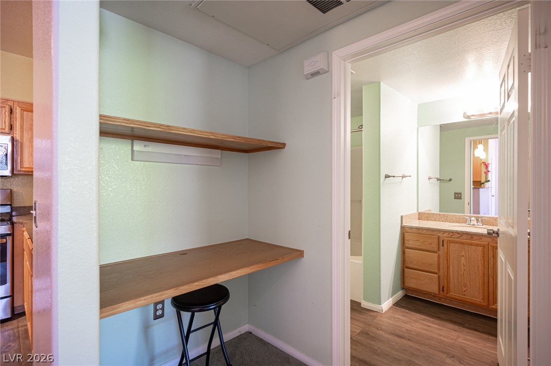 10550 West Alexander Road, Unit 2014 Las Vegas, NV 89129 - Photo 19 of 35 Functional built-in desk with shelving perfect for a home office, adjacent to a well-appointed bathroom.