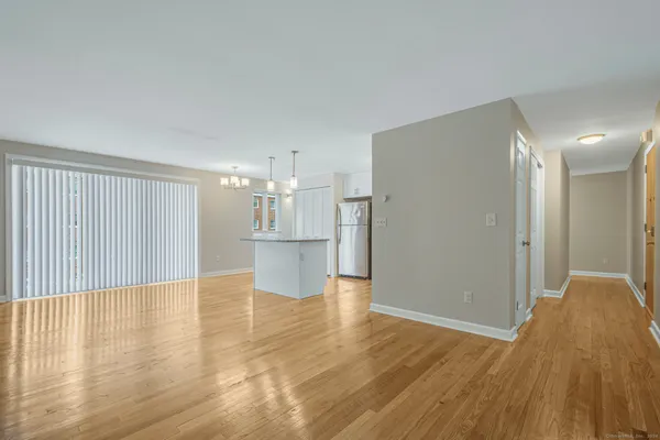 a view of a big room with wooden floor and windows