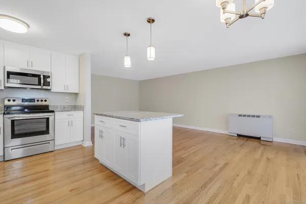 a kitchen with granite countertop white cabinets and stainless steel appliances