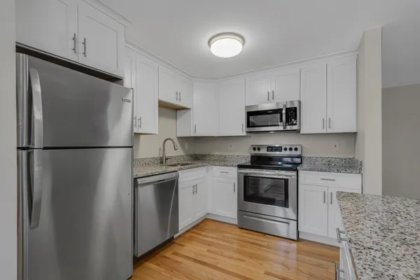 a kitchen with stainless steel appliances granite countertop a refrigerator stove a sink and a microwave
