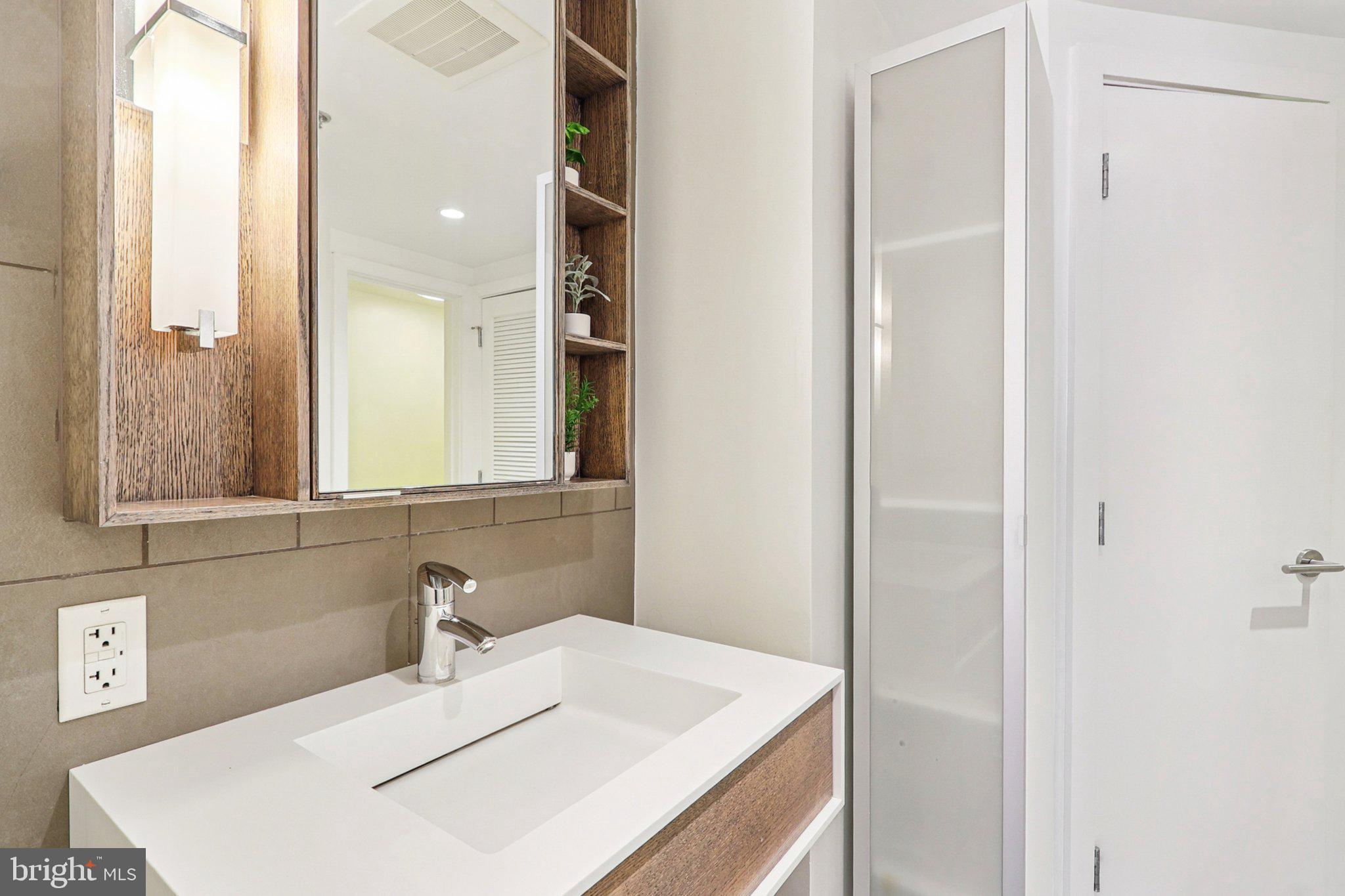 1515 15th Street Northwest, Unit 406 Washington, DC 20005 - Photo 14 of 26 a bathroom with a sink and a mirror