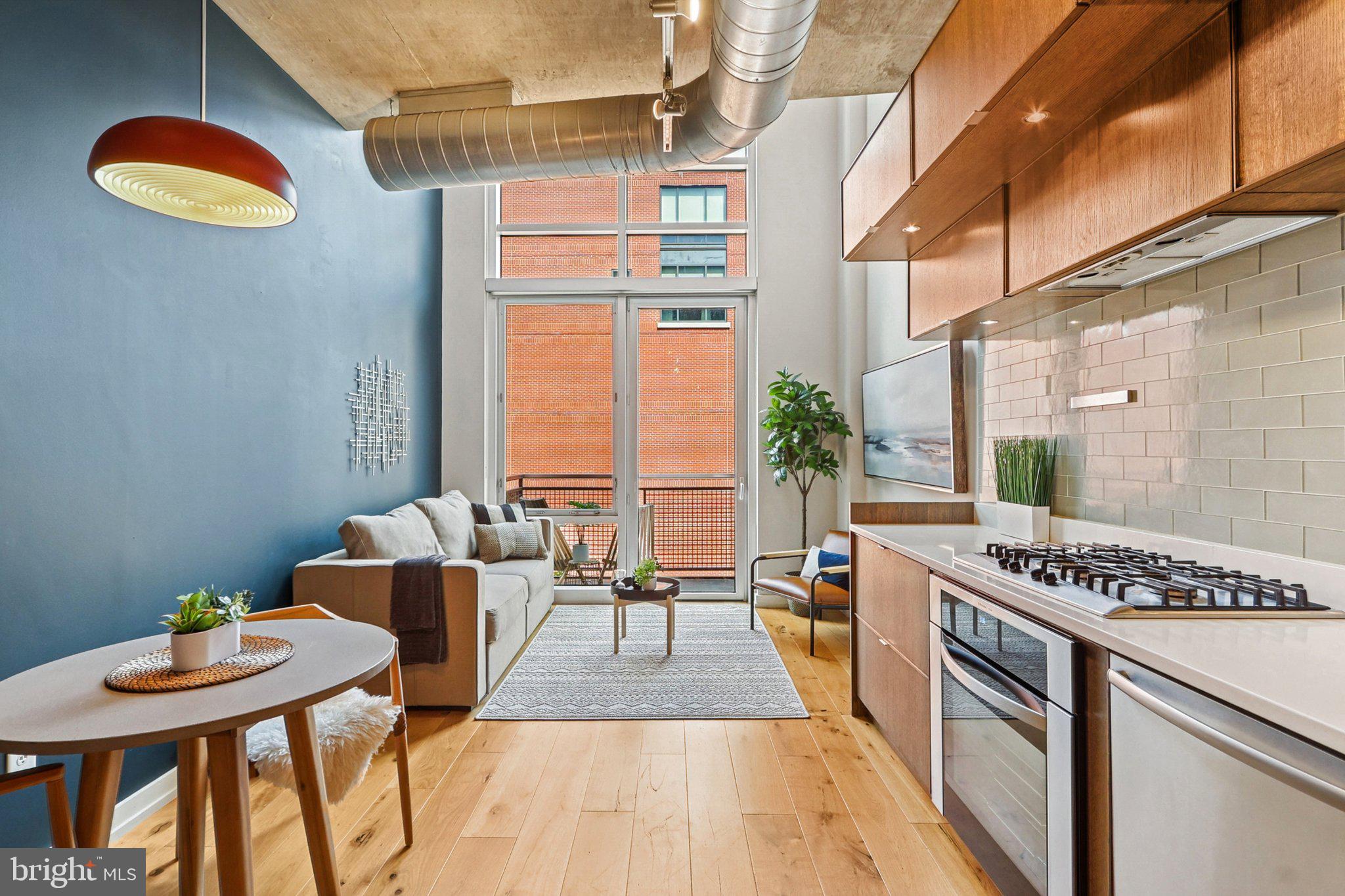 1515 15th Street Northwest, Unit 406 Washington, DC 20005 - Photo 3 of 26 a kitchen with stainless steel appliances granite countertop a stove and a dining table