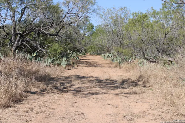a view of dirt road with a building