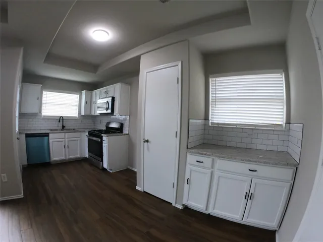 a kitchen with white cabinets and white appliances
