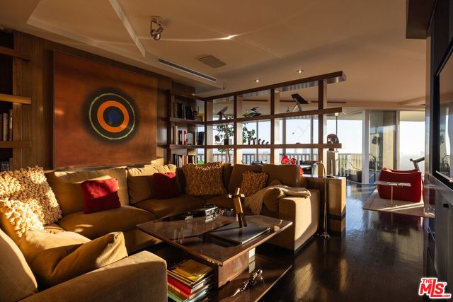 a living room with furniture and a floor to ceiling window