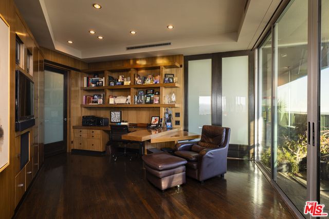 a living room with furniture floor to ceiling window and wooden floor