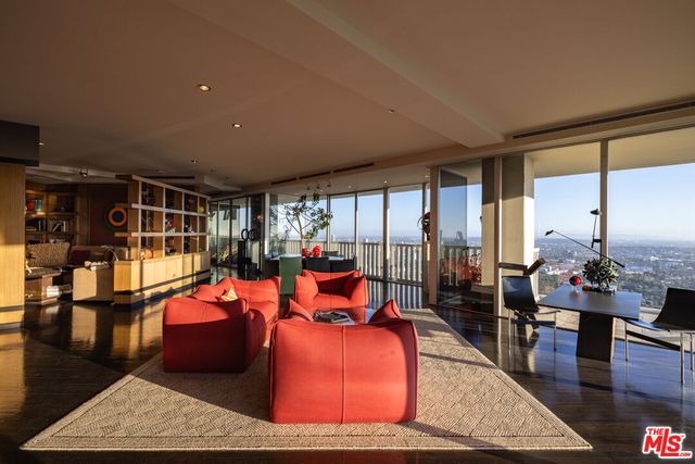 a living room with furniture a rug and a floor to ceiling window