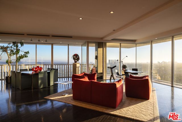 a living room with furniture and a floor to ceiling window