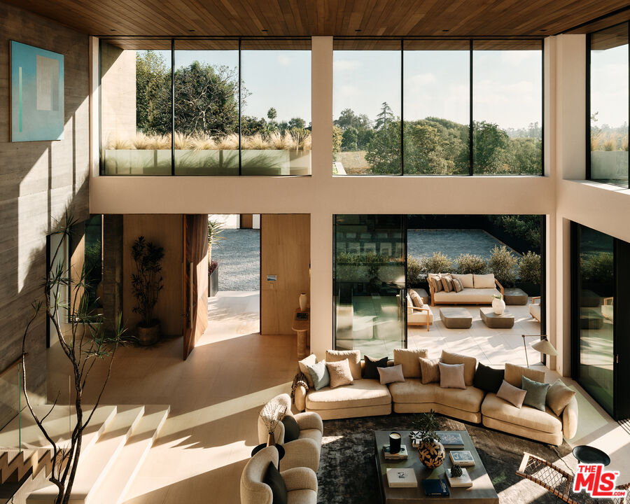 401 North Tigertail Road Los Angeles, CA 90049 - Photo 7 of 41 a living room with furniture and a floor to ceiling window