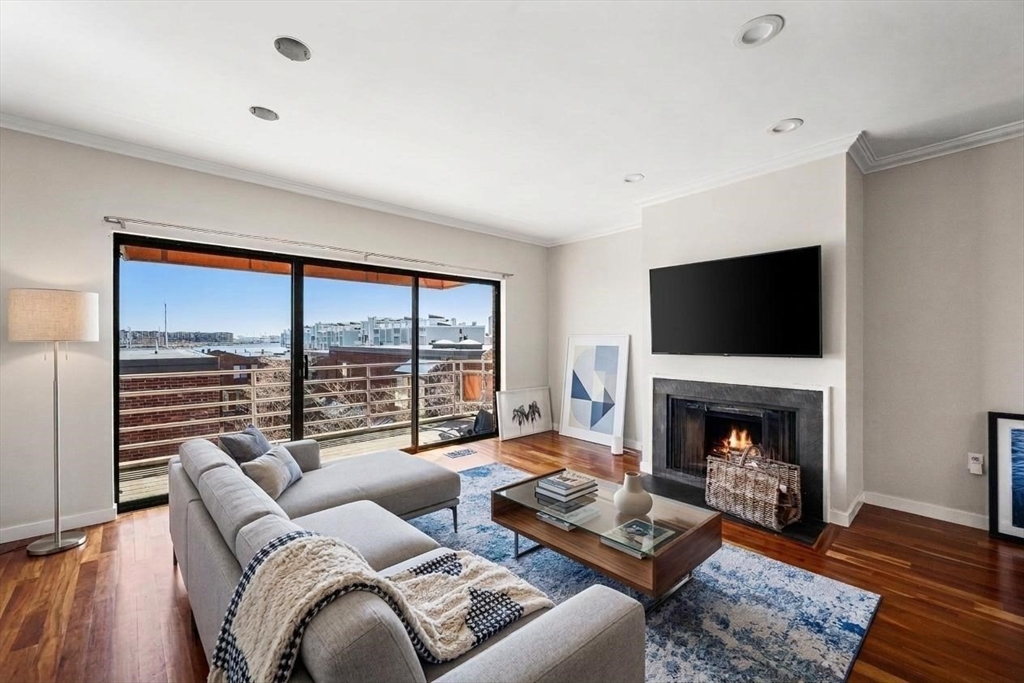 32 Shipway Place, Unit 32 Boston, MA 02129 - Photo 2 of 19 a living room with furniture large window and a fireplace