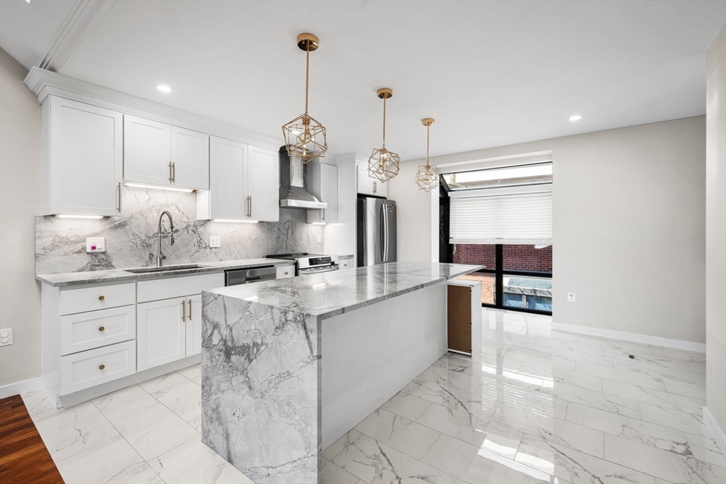 32 Shipway Place, Unit 32 Boston, MA 02129 - Photo 6 of 19 a kitchen with stainless steel appliances granite countertop a sink and white cabinets