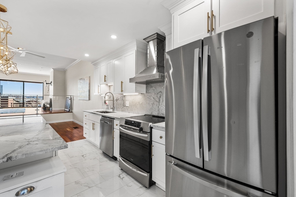 32 Shipway Place, Unit 32 Boston, MA 02129 - Photo 7 of 19 a large kitchen with stainless steel appliances granite countertop a stove refrigerator and cabinets