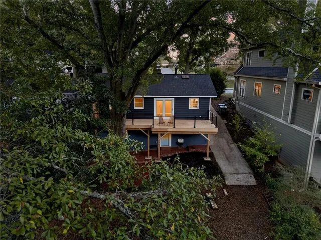 a front view of a house with a small yard and large tree