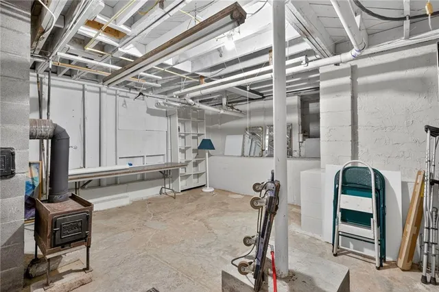 a backyard of a house with plants and large tree