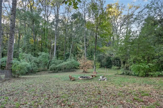 a view of a house with a small yard and a tree