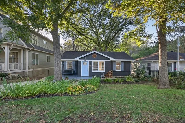 a front view of a house with a garden and trees